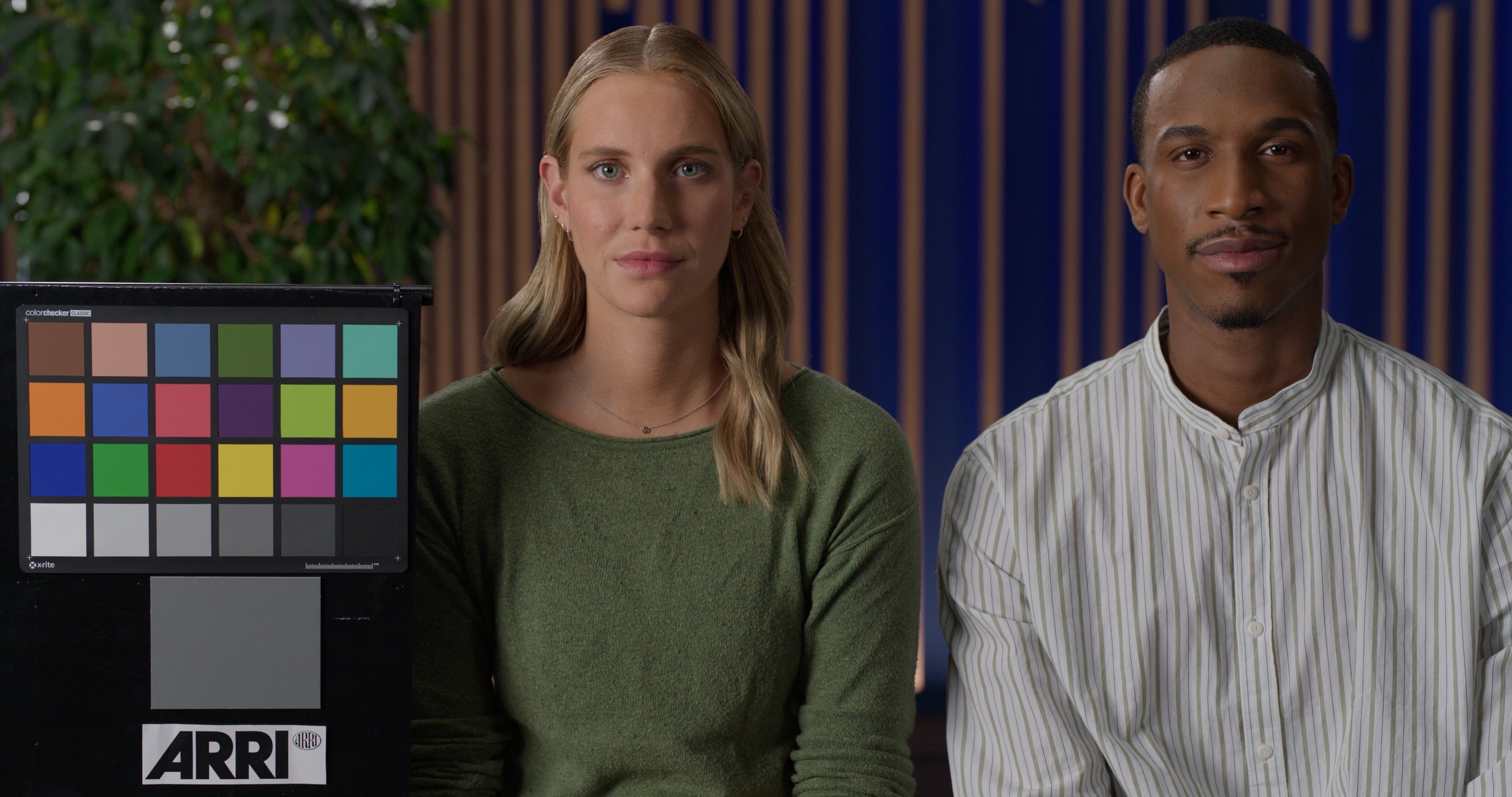 Two people with different complexions beside a color checker chart in mixed studio light, plain Rec.709 conversion