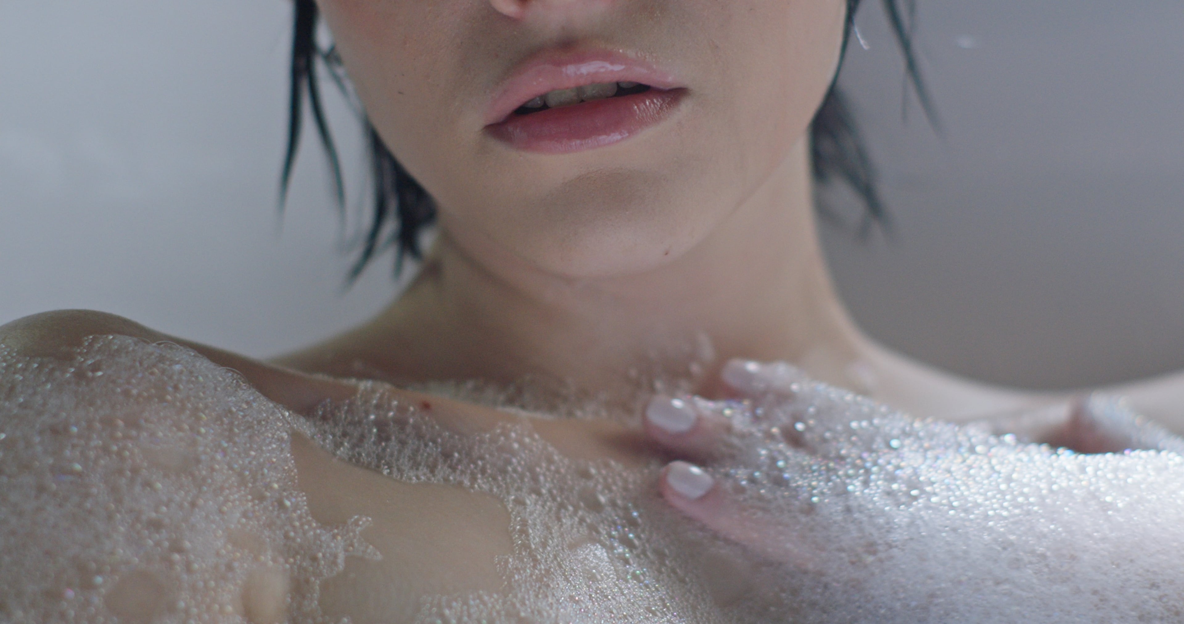 High-key close-up of a woman's face and foamed shoulders in a bath, plain Rec.709 conversion