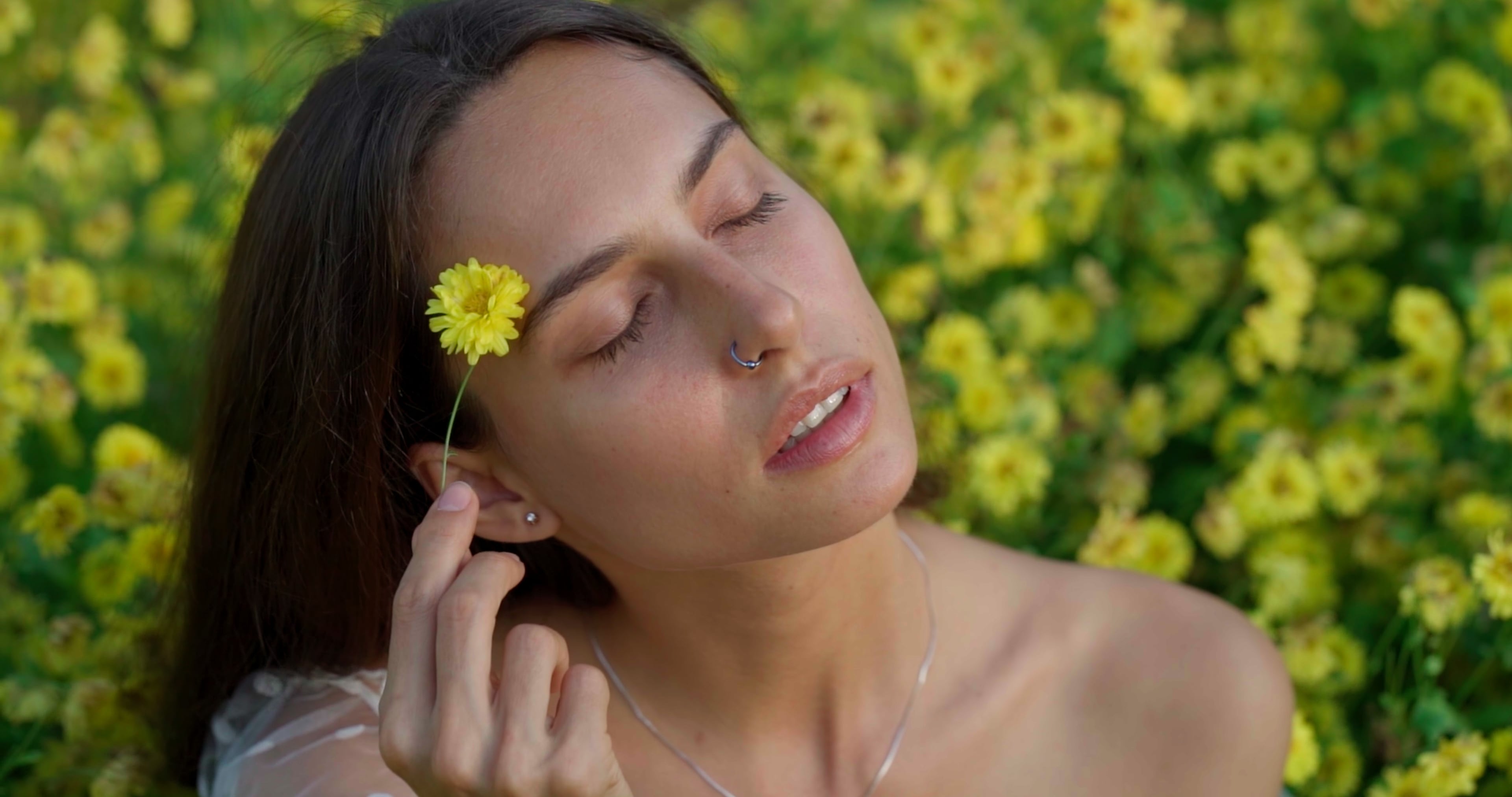 Woman holding a yellow chrysanthemum among yellow flowers, plain Rec.709 conversion